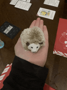 a person holding a stuffed hedgehog in their hand