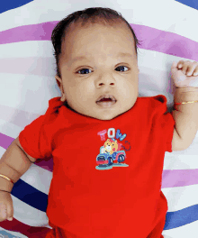 a baby is wearing a red shirt that says tow on it