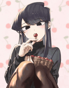 a girl is eating a cherry with a basket of cherries in the background