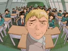 a man in a suit sits in front of a classroom full of people