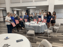 a group of women are standing around a table with flags on it