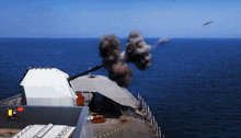 a military ship is firing a cannon at the ocean