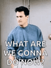 a man in a blue shirt is standing in front of a door with the words `` what are we gonna do now ? ''