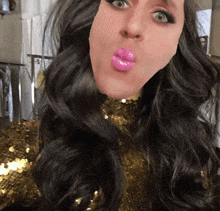 a woman wearing a gold sequined top with pink lips