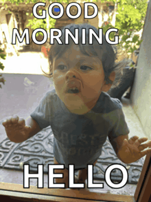 a baby looking out a window with the words " good morning hello " on it
