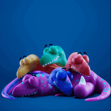 a group of colorful dinosaurs are laying on a blue surface