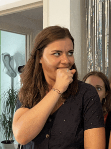 a woman covering her mouth with her hand and a ring on her finger