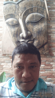 a man is taking a selfie in front of a statue of buddha