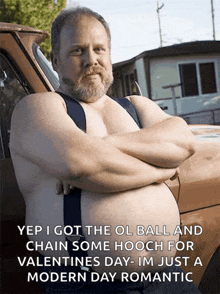 a man with a beard is standing in front of a truck with his arms crossed