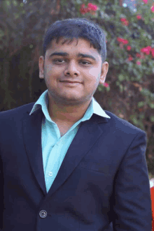 a man wearing a suit and a green shirt is smiling