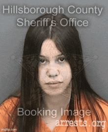 a woman in an orange shirt is in a booking image from the sheriff 's office .