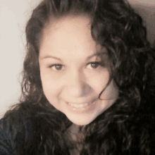 a close up of a woman with curly hair smiling