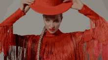 a woman wearing a red top with fringe and a red hat on her head