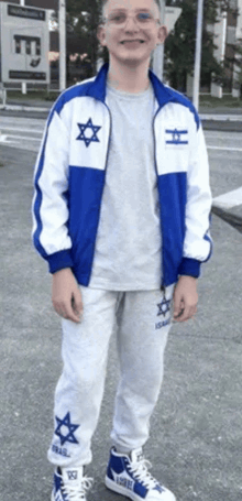 a boy wearing a blue and white jacket with a star on the front