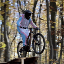 a person wearing a pink and white jumpsuit is riding a bike