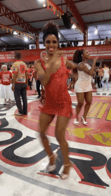 a woman in a red dress is dancing in front of a sign that says ' rio de janeiro para todos '