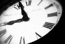 a black and white photo of a clock with roman numerals on it