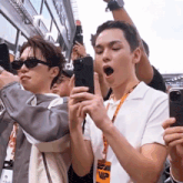 a man wearing a lanyard with the word vip on it looks at his phone