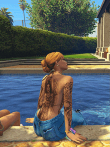 a woman with a tattoo on her back sits near a pool