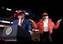 a man in a cowboy hat stands at a podium next to a woman
