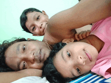 a man and two children laying on a bed together