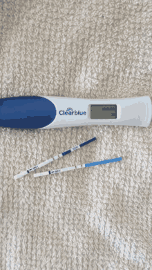 a clearblue digital pregnancy test is sitting on a blanket