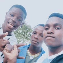 three young men are posing for a picture and one has a nfl necklace on his chest