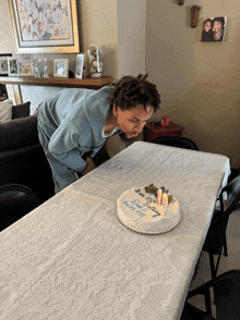 a man is blowing out candles on a birthday cake