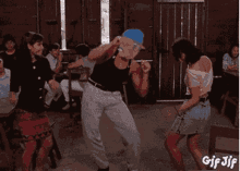 a group of people are dancing in a room with gif jif written on the bottom