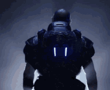 a man in a futuristic suit has two lights on the back of his jacket