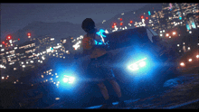 a man stands in front of a car with blue lights