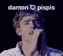 a man is singing into a microphone with the words `` damon pispis '' written above him .