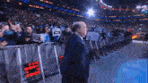 a man in a suit stands in front of a crowd holding a sign that says ' i love you ' on it