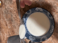 a spoon is being poured into a bowl of liquid