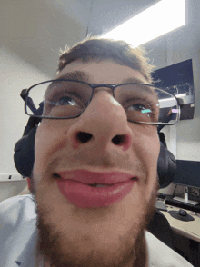 a man wearing glasses and headphones is smiling