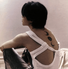 a woman with a tattoo on her back of a crescent moon