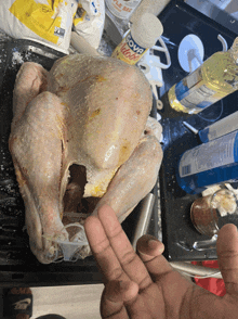 a person holds up their finger in front of a turkey and a bottle of liquid proof