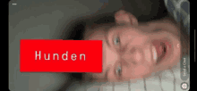 a man is laying on a bed with his mouth open and a red sign that says honden .