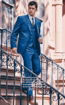 a man in a blue suit and tie is standing on stairs