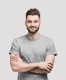 a man wearing a grey t-shirt with his arms crossed