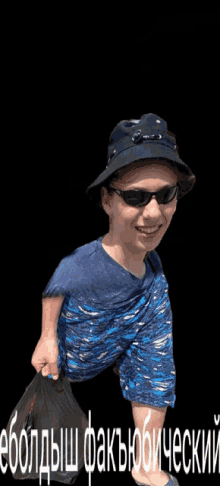 a boy wearing a hat and sunglasses is holding a bag in front of a black background with russian writing