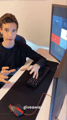 a boy sitting at a desk with a keyboard and a mouse with the words giveaway written below him