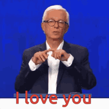a man in a suit and glasses says " i love you " in red letters