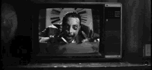 a black and white photo of a man on a television with the letters kk on the bottom right