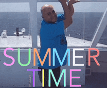 a man in a blue shirt stands on a boat with the words summer time above him