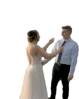 a bride and groom are standing next to each other and the bride is trying to tie the groom 's tie