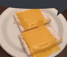 two toaster pastries covered in cheese are on a paper plate