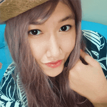 a close up of a woman 's face wearing a straw hat