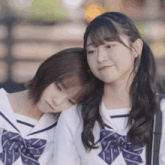 two girls in school uniforms are standing next to each other