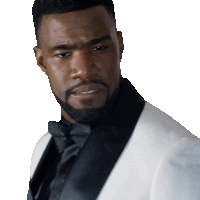 a man with a beard wearing a white tuxedo and black tie